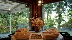 una mesa con cestas y un jarrón de flores. en Country Hotel Le Querce, en Salsomaggiore Terme