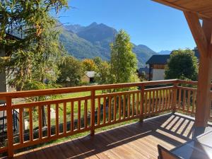 a wooden deck with mountains in the background at Charmant logement à Serre Chevalier in Puy-Saint-Pierre