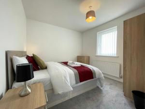 a bedroom with a bed and a table with a lamp at Moor View Professional Let in Durham