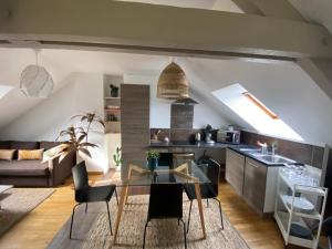 a kitchen and living room with a glass table at Appartement hyper centre cathédrale avec parking gratuit in Amiens