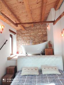 a bathroom with a bath tub and a sink at Romantico Chalet in pietra da mille e una notte in Petralia Soprana