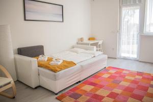 a bedroom with a white bed and a colorful rug at FodorMenta Residence in Eger