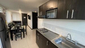 a kitchen with a sink and a table in it at Apartahotel cerca Parque del Café, 506A in Montenegro