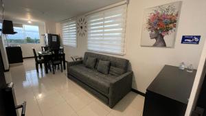 a living room with a couch and a table at Apartahotel cerca Parque del Café, 506A in Montenegro