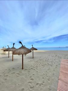 ジブラルタルにあるHoliday studio apartment near the beach and city centreの浜辺の藁傘 +6枚の写真