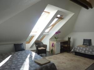 a attic room with a bed and a desk and windows at Veľký apartmán v rodinnom dvojdome, Free Parking in Košice
