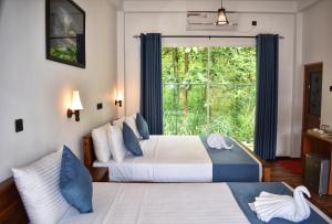 due letti in una stanza con finestra di Forest Edge Safari Villa a Udawalawe