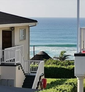 a house with a staircase leading to the ocean at Hello Holiday at 4 Boboyi Mangrove Beach Estate in Port Shepstone