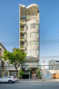 a tall building with a car parked in front of it at Thanh Lan - City River View Hotel in Danang