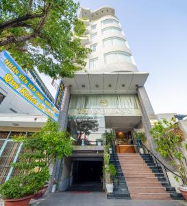 a large white building with stairs in front of it at Thanh Lan - City River View Hotel in Danang