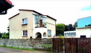 una casa vieja con una valla delante de ella en Queens house en Oświęcim