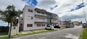 a white car parked in front of a building at Apartamento Ponta do Papagaio - Térreo in Palhoça