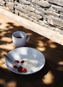 Un plato con fresas y una taza de café sobre una mesa. en Deluxe Apartment in Historic Quarter near Beaches, en Aberystwyth