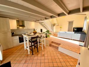 a kitchen and living room with a table and chairs at LA BERGERIE DU DAMIAN in Neuville