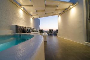 a large pool in a room with a couch at Aerino Villa in Firostefani