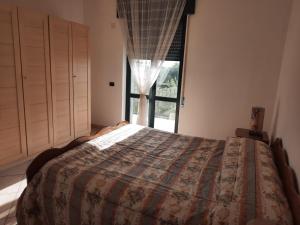 een slaapkamer met een bed en een raam bij La Rosa dei Venti Apartments in Eboli
