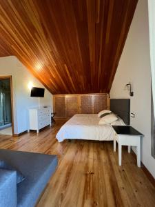 a bedroom with a bed with a wooden ceiling at Hotel Regueiro in Tox