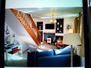 The Wee Anchor في آربروث: غرفة معيشة مع أريكة زرقاء ودرج