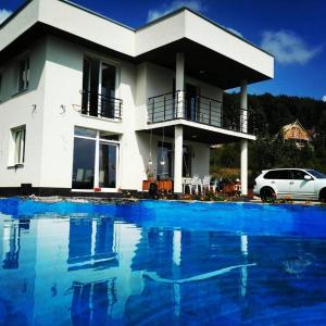 a house with a swimming pool in front of it at LUX Villa Mavrovo in Mavrovo