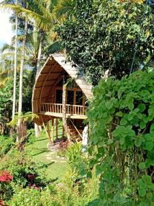 a small bamboo house in the middle of a garden at Jero Tumbuk Private Villa in Selat