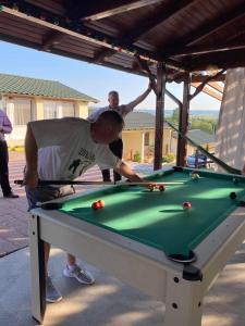 ein Mann spielt Billard auf einem Billardtisch in der Unterkunft Complex Turistic Dávid in Boghiş
