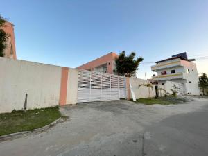 uma cerca branca ao lado de um edifício branco em Apartamento duplex em Arembepe em Arembepe