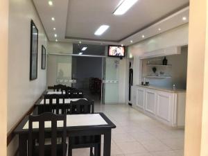 a dining room with tables and chairs and a bar at Regio Plaza Hotel in Ourinhos