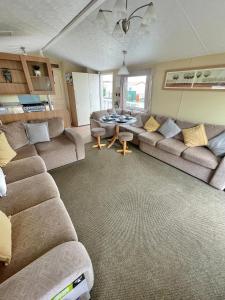 uma sala de estar com sofás e uma mesa em Golden Palm Chapel St Leonards 8 Berth 3 Bedroom Caravan em Skegness