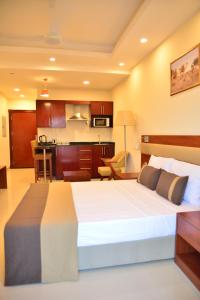 a bedroom with a large bed and a kitchen at RED SEA HOTEL APARTMENT in Djibouti