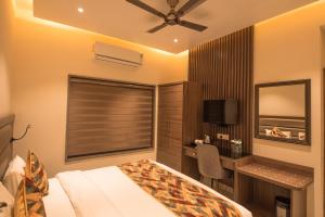 1 dormitorio con cama, escritorio y ventana en Vashishth Guest House, en Rishīkesh