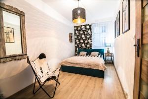 ein Schlafzimmer mit einem Bett und einem Stuhl darin in der Unterkunft AP Apartment's Gdańska in Wałbrzych