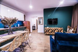 ein Wohnzimmer mit einem Tisch und einer blauen Wand in der Unterkunft AP Apartment's Gdańska in Wałbrzych