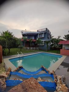 ein Haus mit einem Pool vor einem Haus in der Unterkunft Karjat - 3 BHK Private Bungalow with Private Pool & Garden in Karjat
