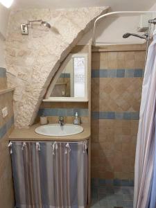 un baño con lavabo y ducha en Il Giardino del Borgo, en Cisternino