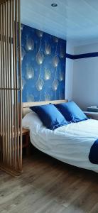 Schlafzimmer mit einem Bett mit blauer Wand in der Unterkunft Aux 77 Nuitées in Trilport
