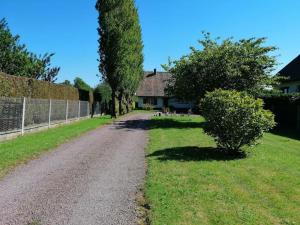 a dirt road in front of a house with trees at Maison calme avec jardin, Petit-Caux in Bracquemont