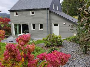 埃爾伯蒙的住宿－Gite d'Arbûmont，前面有粉红色花的灰色房子