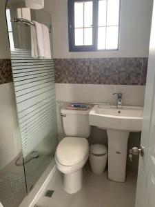 a white bathroom with a toilet and a sink at Lucerna 3 in La Cana