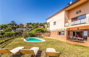 uma casa com um quintal com cadeiras e uma piscina em Cozy Home In Sant Cebri De Vallalta With House Sea View em Sant Cebrià de Vallalta