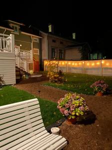 a white bench in front of a house with lights at Eleonora Bed & Breakfast in Kristinestad