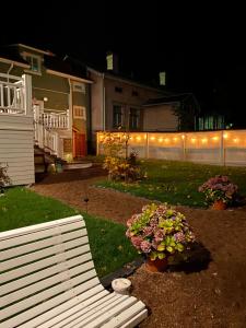 a white bench in front of a house with lights at Eleonora Bed & Breakfast in Kristiinankaupunki
