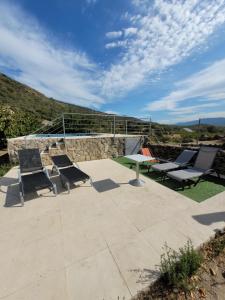 a group of chairs and a table on a patio at Casa Rural Canchal Madroñeras *** in El Torno