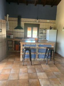 una cocina con 2 taburetes y una barra en Casa Rural Canchal Madroñeras ***, en El Torno