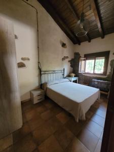 a bedroom with a large white bed in a room at Casa Rural Canchal Madroñeras *** in El Torno