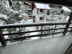 a balcony with snow covered trees and a railing at Vila Amira Predeal in Predeal