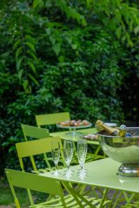 a table with three wine glasses and a bowl on it at L'Hôtel Particulier - Paris Asnières in Asnières-sur-Seine