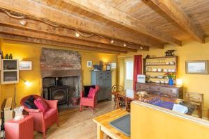 a living room with a fireplace and a table and chairs at The Cottage By The Sea, Scotland in Burnmouth