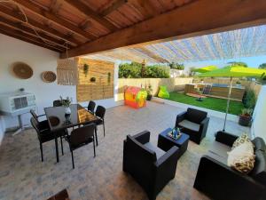 une terrasse avec une table, des chaises et un parasol dans l'établissement A CASA DA VILA, à Ermidas