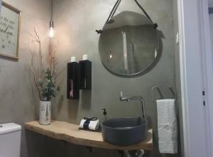 La salle de bains est pourvue d'un lavabo bleu et d'un miroir. dans l'établissement A CASA DA VILA, à Ermidas