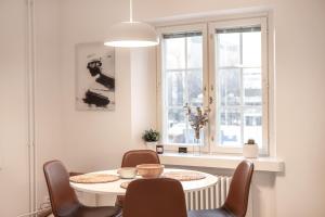 a dining room with a table and chairs and a window at ULEABO New, Light and Roomy 61m² Apartment With Sauna! in Oulu